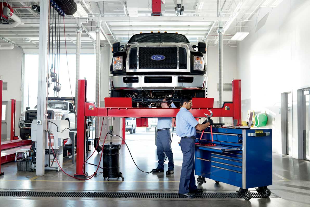 Mecánicos trabajando en el taller Ford revisando un vehículo 