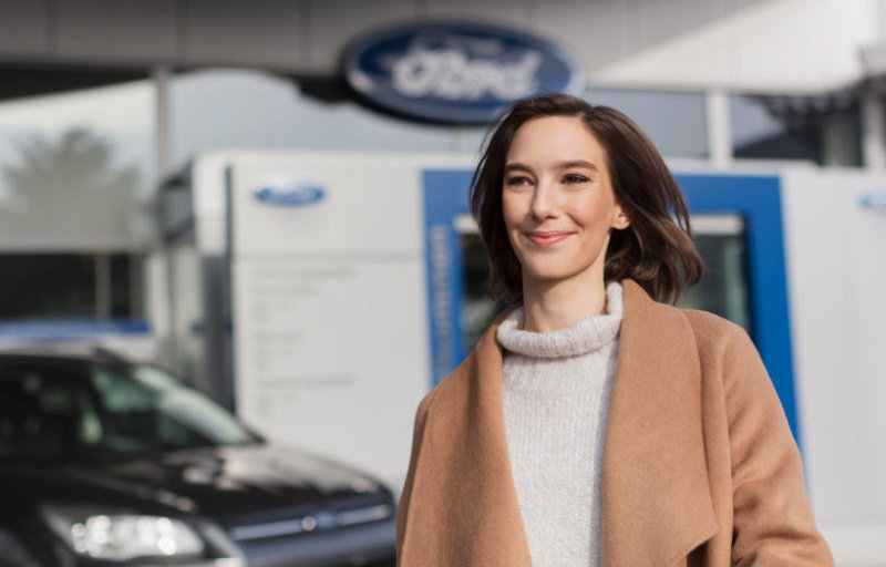 Lächelnde Frau in Ford Garage