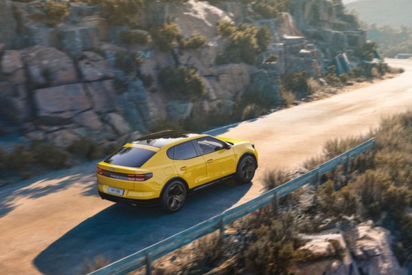 Ford Capri Frd Capri fährt entlang hügeliger Strasse mit karger Landschaft im Hintergrund