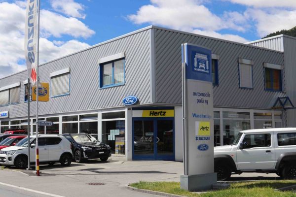 Bild der Garage an sonnigem Tag mit Occasionen auf Parkplatz davor