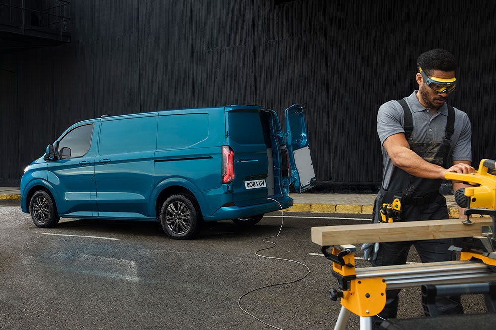 Fourgon électrique Ford E-Transit Custom bleu et une personne utilisant des outils électriques