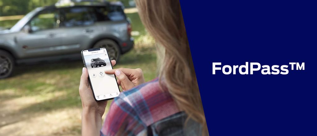 Ford Bronco Sport ao fundo e mulher interagindo com o aplicativo FordPass no celular