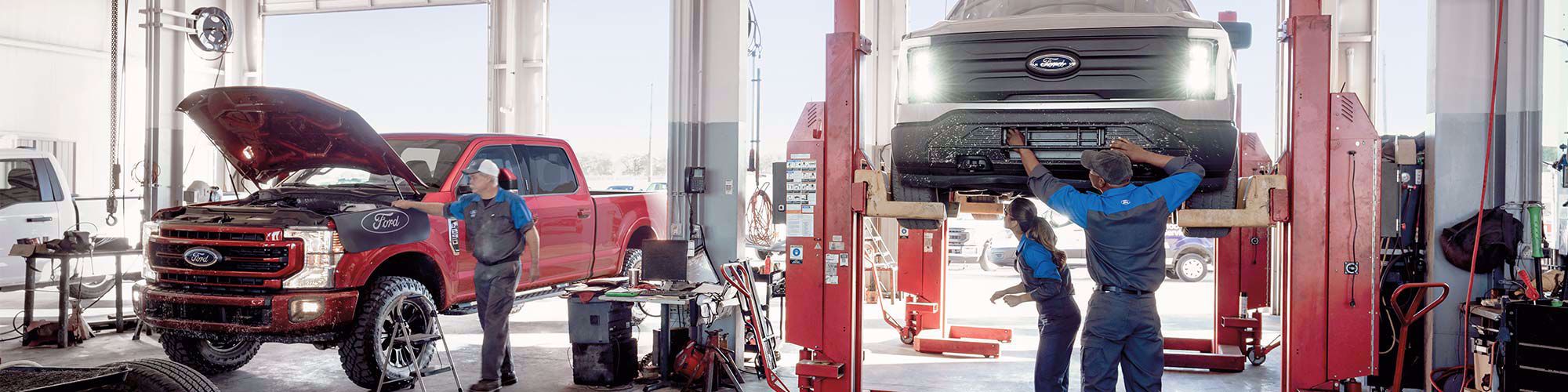 Trabajadores de taller reparando autos Ford