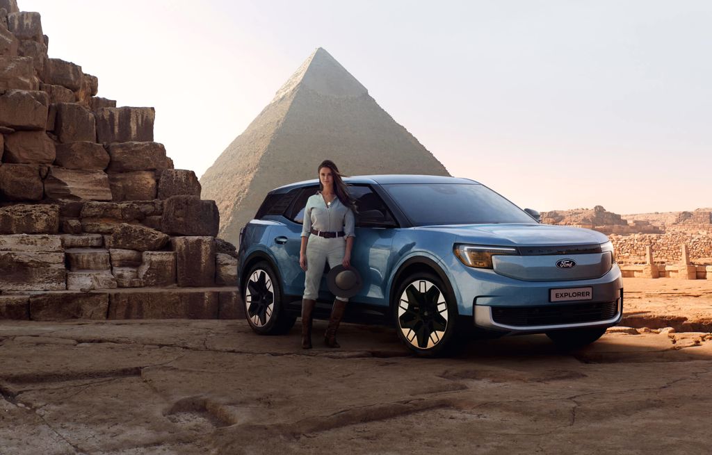 Abenteurerin Lexie Alford neben blauen vollelektrischen Ford Explorer vor den Pyramiden 